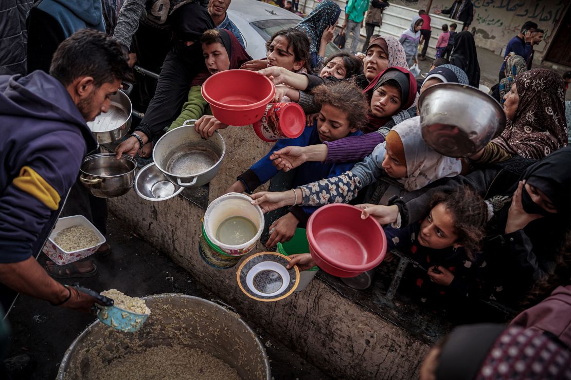 Children and families receiving food distribution in refugee camp
